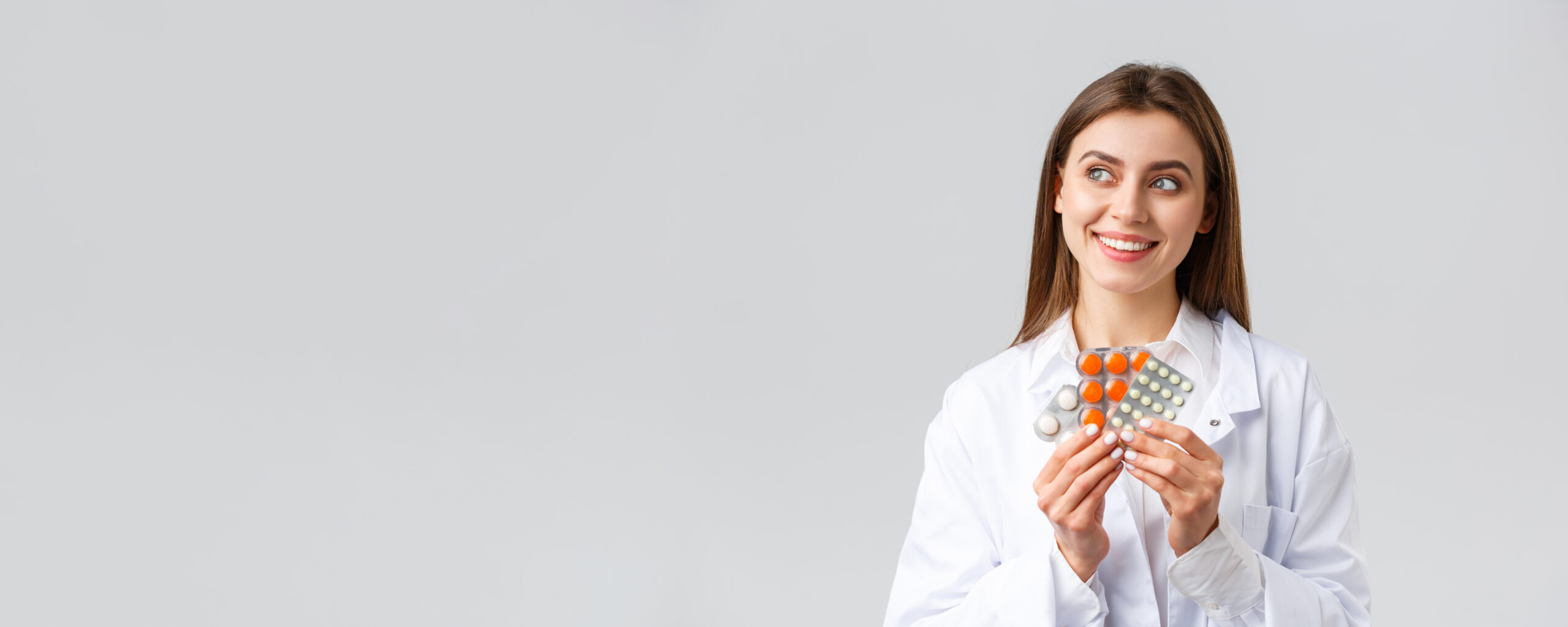 pharmacy-healthcare-workers-insurance-hospitals-concept-thoughtful-smiling-pleased-female-doctor-white-scrubs-look-away-thinking-holding-medicine-pills-vitamins
